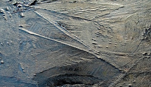 Durch den Frost zu Eis erstarrt ist die Oberfläche einer Pfütze.